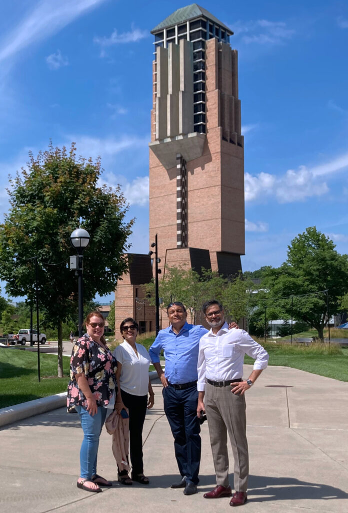 TalentSprint and Nexus representatives stand in front of the University of Michigan North Campus bell tower